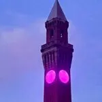 The clock at Birmingham University with purple lighting.